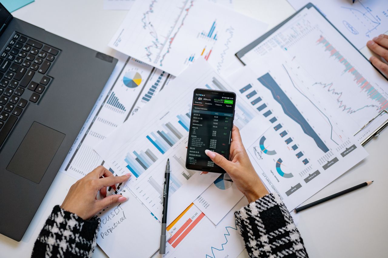 A top-down view of charts and a smartphone in an office, illustrating data analytics.